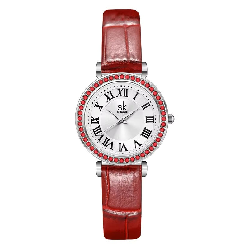 Wristwatch with red strap and gemstone accents on a white background