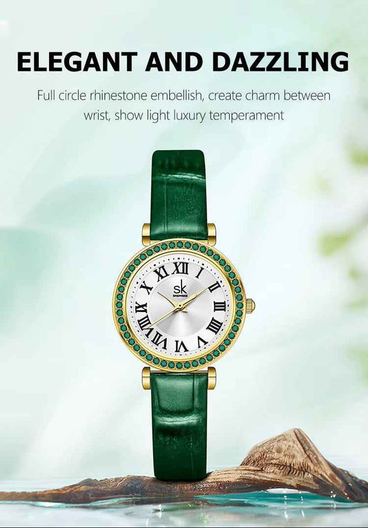 Green wristwatch with rhinestone embellishments on a blurred natural background